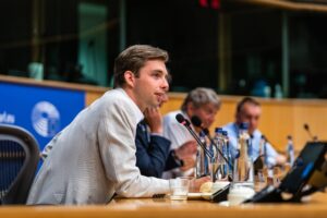 Gespreksleider staat voor zaal en stelt vragen