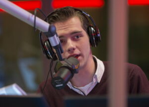 Presentator maakt podcast door in microfoon te praten